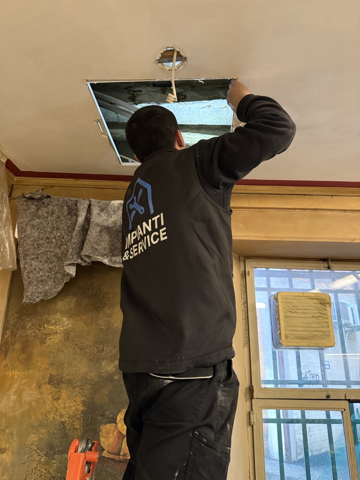 Tecnico IMPIANTI&SERVICE durante un montaggio tecnico a soffitto